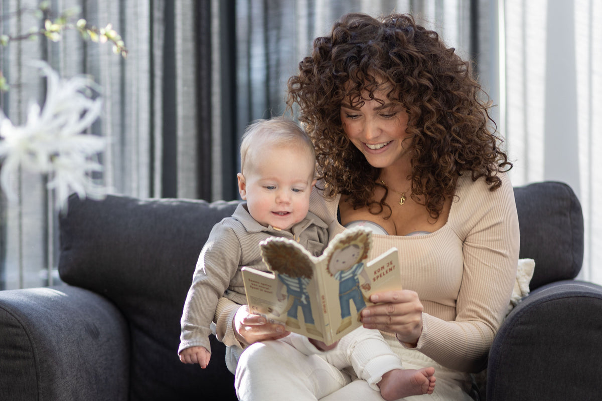 Moeder leest met haar baby een blad terwijl ze zich voorbereidt op borstvoeding, met tips voor een succesvolle start van de borstvoedingsreis.