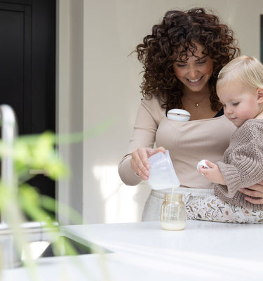 Moeder kolft comfortabel en handsfree met een Youha borstkolf, terwijl ze haar baby voedt. Efficiënt en gemakkelijk moedermelk afschenken met de innovatieve Youha borstkolven.