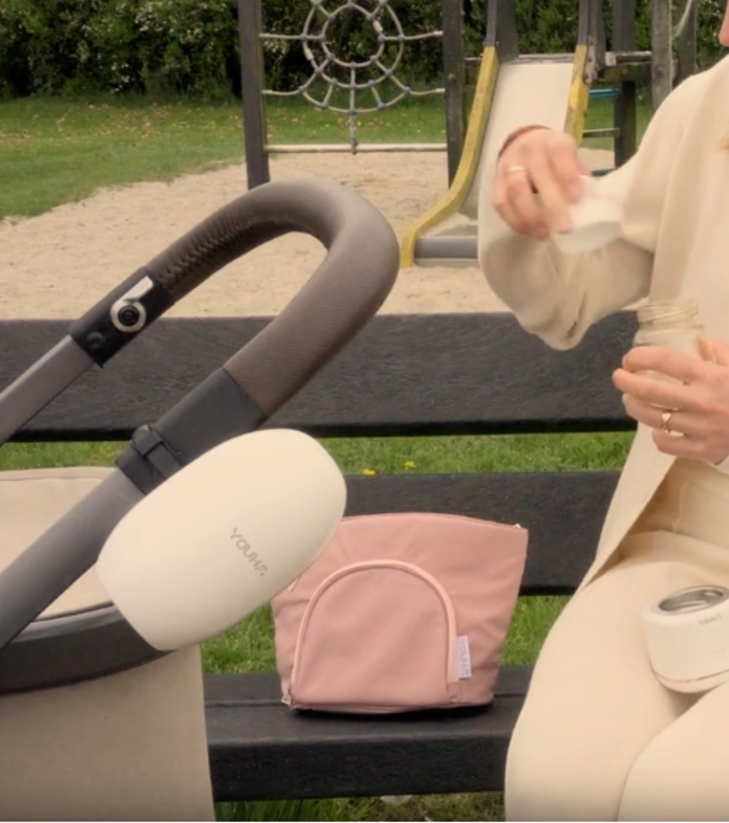 Moeder wandelt met haar baby in het park met de Youha Baby Rocker aan de kinderwagen